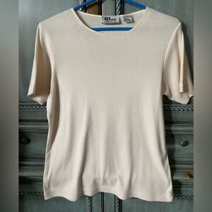 Off-white cotton blend knit top with short sleeves and round neckline.